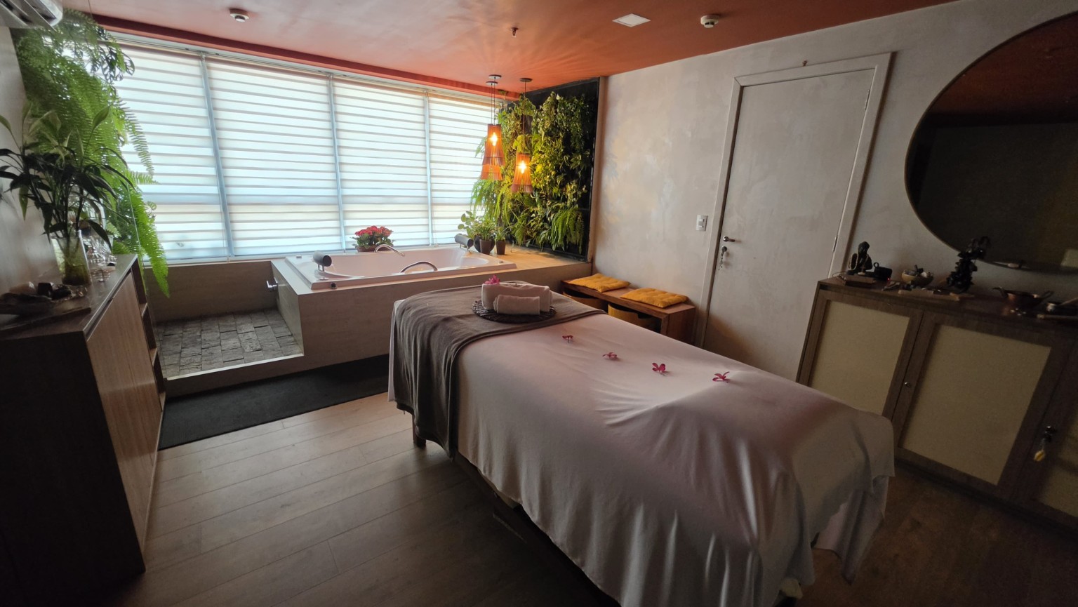 Sala do Axis Mundi Spa com massagem, banheira e jardim vertical